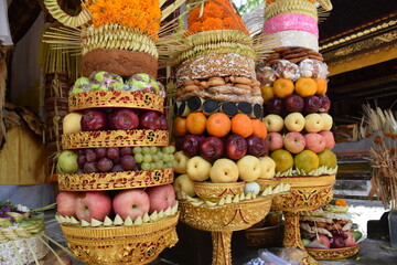 
religious food offering, very varied and colorful fruit, assorted sweets and flowers, hinduism in a temple in bali, indonesia