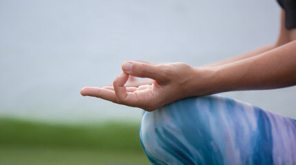 Mujer joven practicando yoga con las manos en posición de mudra 