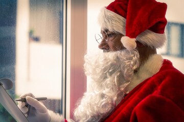 Obraz premium santa claus making his gift list