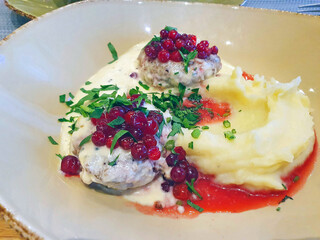 poultry cutlets with mashed potatoes and lingonberry-berry sauce, sprinkled with herbs