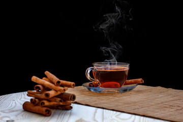 aromatik sıcak tarçın çayı ve ahşap masa üzerinde karanfil tohumları