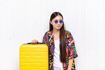 asian young woman looking proud, confident, cool, cheeky and arrogant, smiling, feeling successful. holidays concept