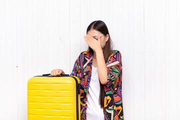 asian young woman covering face with hand and putting other hand up front to stop camera, refusing...