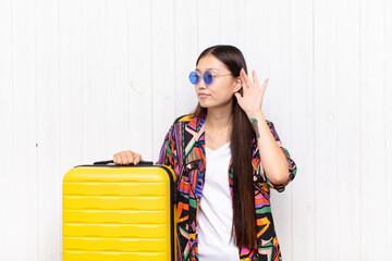 asian young woman looking serious and curious, listening, trying to hear a secret conversation or...