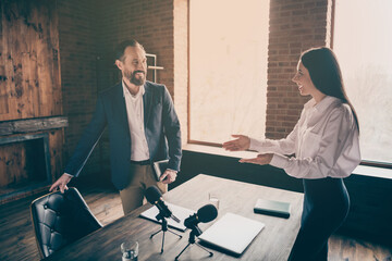 Profile photo of two people businessman business lady partnership colleagues press conference secretary offer sit down famous professor reportage microphone table office indoors