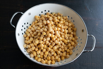 Soaked Chickpeas Drained in a Colander: Dried garbanzo beans that have been soaked in water and drained in a colander