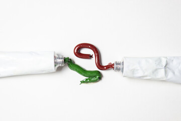 Tubes of paint on a white background. The paint is squeezed out of the tube. Red and green paints