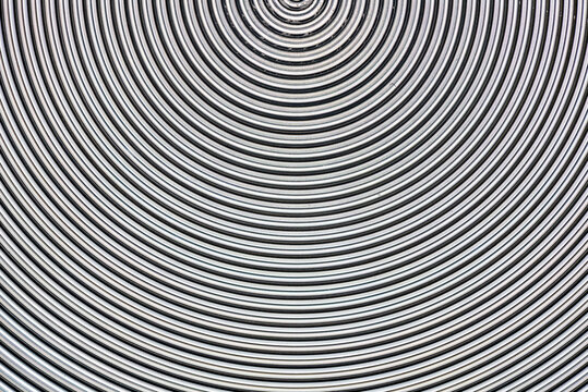 Aluminum metal surface with spiral pattern texture closeup photo background.