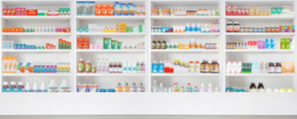 Empty wood counter top with pharmacy drugstore shelves blur pharmaceutical medicine product...