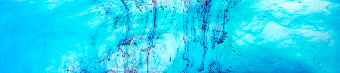 Closeup of a blue, black and red ink in water in motion isolated on white. Ink swirling underwater. Colored abstract smoke explosion effect. Abstract background with copy space..