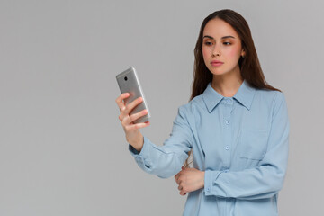 Beautiful young woman is making selfie photo with smartphone.