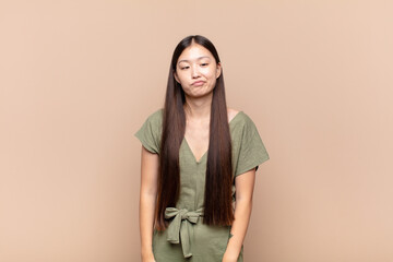 asian young woman looking goofy and funny with a silly cross-eyed expression, joking and fooling...