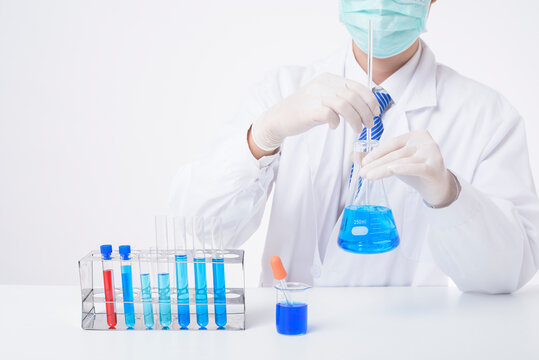 close up of cientist is testing and researching some blue liquid chemical in laboratory isolated white background.