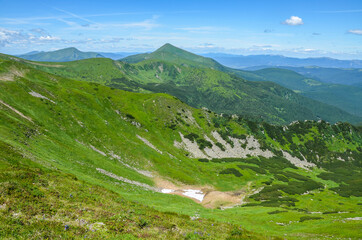 Fototapeta na wymiar Landscape view of green hills of chornohora ridge. Sunny weather with clouds on the blue sky. Beautiful scenery of Carpathian mountains