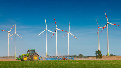 Big wind turbines to generate electrical power, green ecofriendly energy at blue sky standing at...