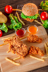 Fired chicken and chicken nuggets and spicy drumsticks on wooden background. Set of fired crispy chicken. Crispy fried chicken in  decoration with ingredient on  wooden table background