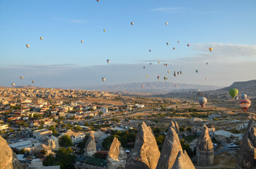 Hot air balloons flying over spectacular rock landscape at sunrise. Cappadocia Turkey.