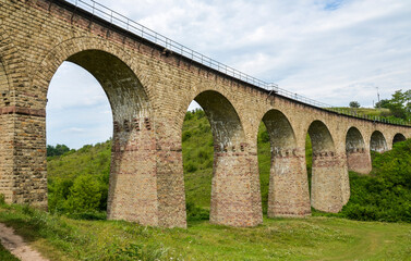 Fototapeta na wymiar Ancient stone viaduct railway bridge built in the time of Austro-Hungarian Empire in Western Ukraine in Ternopil region in the village of Plebanivka