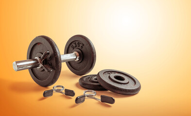 Fototapeta na wymiar Metal dumbbell set. Isolated on orange background. Gym, fitness and sports equipment symbol