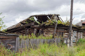 An abandoned old building made of logs, walls and a roof of a residential log house destroyed from time to time.