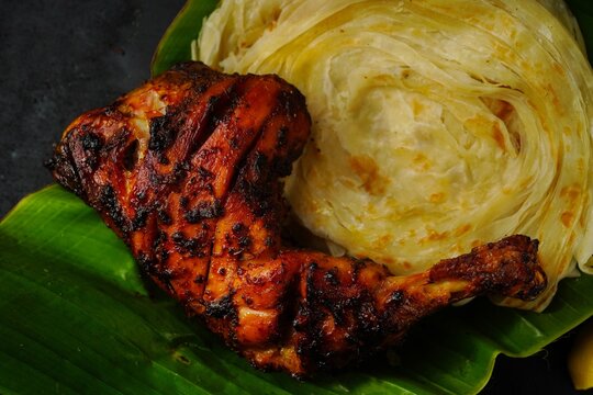 Kerala Parotta or Porotta with grilled chicken, selective focus