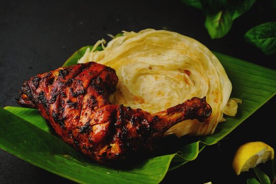 Kerala Parotta or Porotta with grilled chicken, selective focus