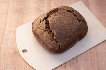 a bun of fresh black Borodino bread baked in a bread machine. Aromatic homemade cakes