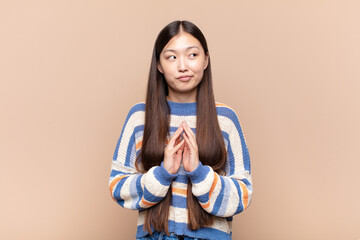 asian young woman scheming and conspiring, thinking devious tricks and cheats, cunning and betraying