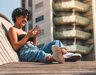 Attractive Brazilian female sitting on the roof with a modern building in the background