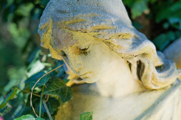 Close up ancient statue of crying angel with tears in face. Horizontal image.