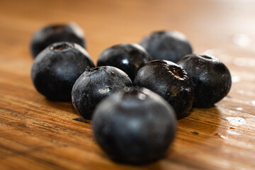primer plano de arandanos fruta violeta en forma de bolas chicas sobre madera