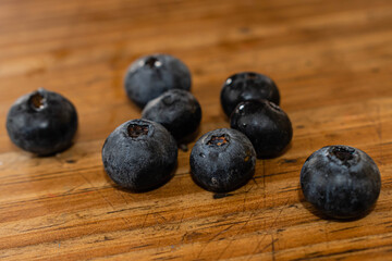 primer plano de arandanos fruta violeta en forma de bolas chicas sobre madera
