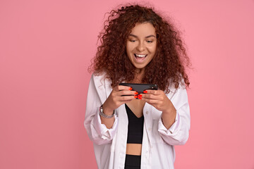 Excited young girl attend cool concert record video for her vlog, stream music festival online via social media, holding smartphone and looking at display with amazed happy face to take shot