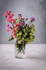 Floral background. Wild roses in a glass jar over stone background. Still Life Flowers. Nature.