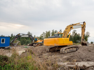 Obraz premium Excavator digs the ground for the foundation and construction of a new building