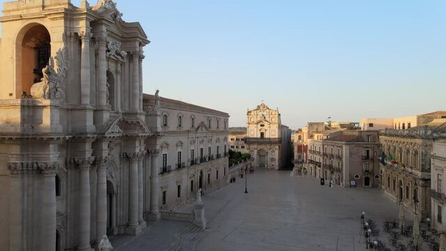 Drone flies down the empty center square of Ortygia (Ortigia) island in Siracusa at sunrise, in Sicily, south Italy