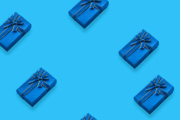 Pattern of gift boxes tied with a ribbon on a light blue background with copy space