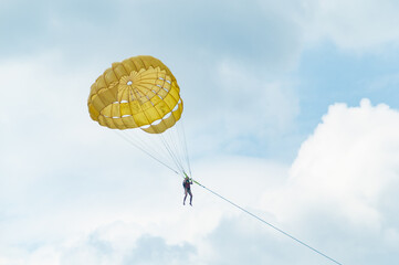 Parasailing in the clouds with a yellow parachute