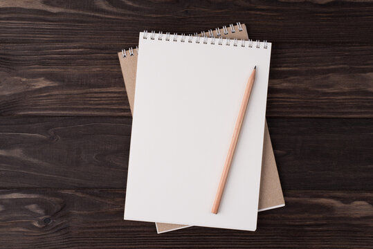 Top above overhead view flat lay photo of a blank notebook and wooden pencil isolated on wooden background with copyspace