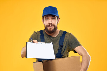 Worker male courier delivering boxes packaging documents yellow background