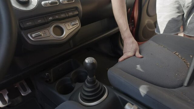 Man cleaning dirty car interior with vacuum cleaner