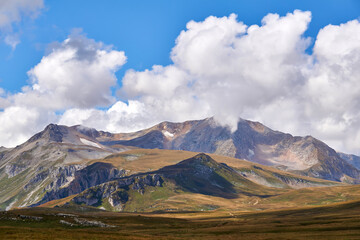 mountain treeless landscape with clouds and blue sky