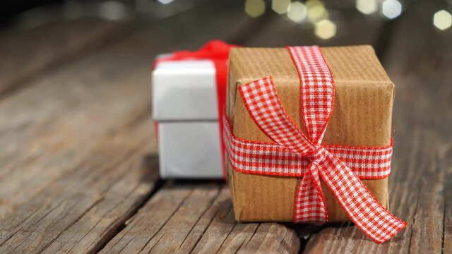 Pan of Christmas gits on old wooden table, bokeh lights background