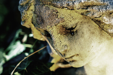 Tears in face of angel as symbol of pain, death and end of human life. Close up. Fragment of ancient statue.