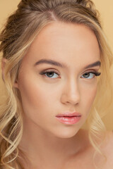 Close-up portrait of young blonde woman in studio, long eyelashes extension, professional fashion makeup