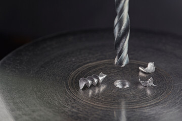 metal drill bit make holes in steel billet on industrial drilling machine. Metal work industry....