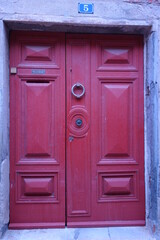 Altes rotes Tor mit Tür Klopfer
