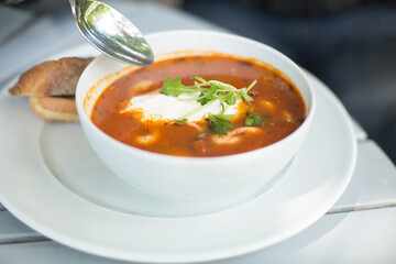 Tomato soup with seafood in a white plate.