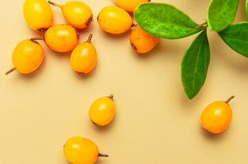 Fresh ripe sea buckthorn on beige background close-up. Background of ripe berries. Macro photography. Fruit organic background. Healthy food, vitamin berry