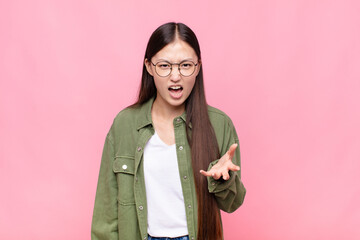 asian young woman looking angry, annoyed and frustrated screaming wtf or what‚Äôs wrong with you